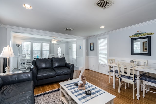 living room with hardwood / wood-style floors, a healthy amount of sunlight, and crown molding