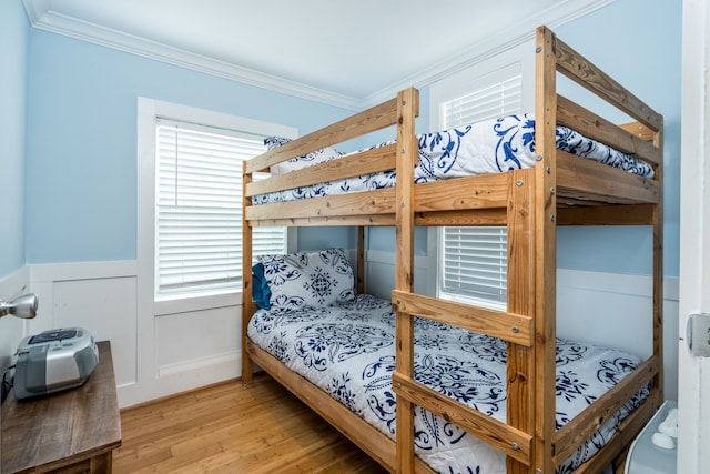 bedroom with ornamental molding and light hardwood / wood-style flooring