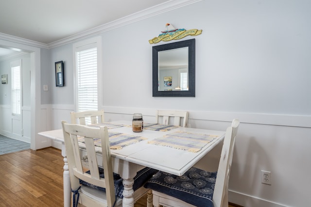 dining room with wood-type flooring and crown molding