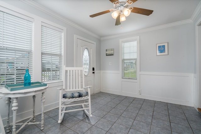 tiled foyer entrance with ceiling fan and crown molding