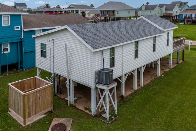 rear view of property featuring a yard and cooling unit