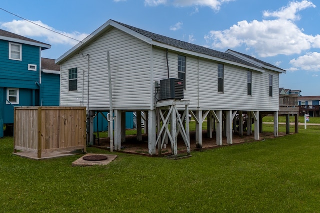 rear view of house featuring a deck, central air condition unit, and a yard