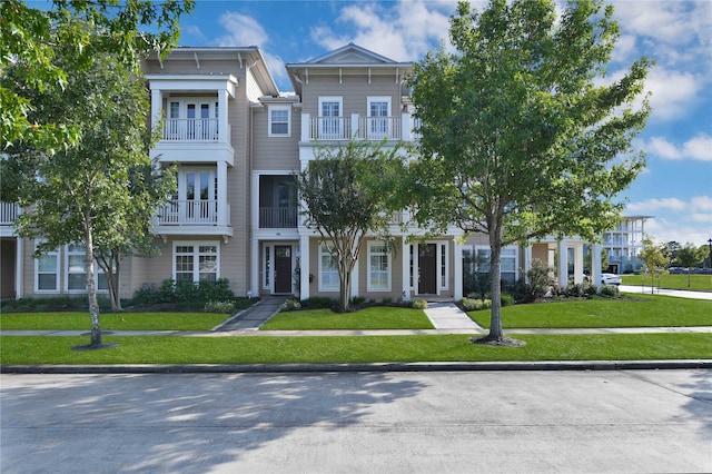 view of front facade with a front yard and a balcony