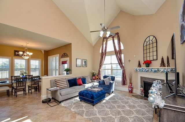 living room with a wealth of natural light, ceiling fan with notable chandelier, light tile patterned floors, and high vaulted ceiling