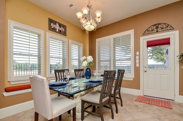 dining area with light tile patterned floors and an inviting chandelier