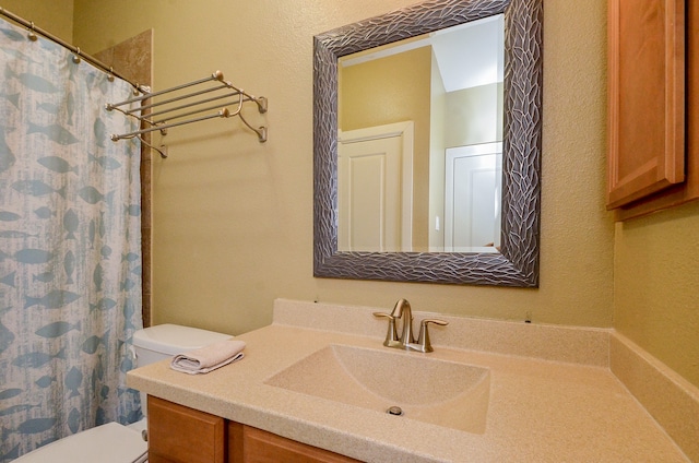 bathroom with curtained shower, vanity, and toilet