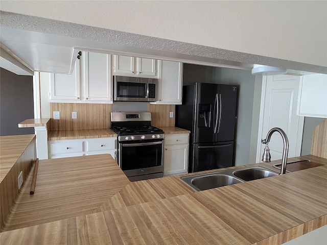 kitchen with white cabinetry, appliances with stainless steel finishes, a textured ceiling, and sink