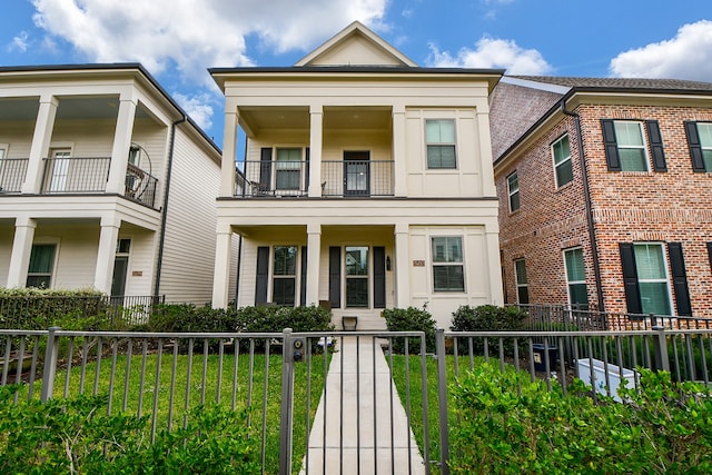 view of front facade with a balcony and a front yard