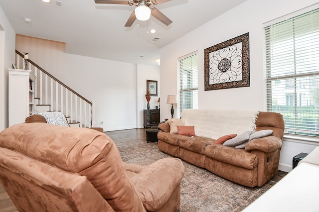 living room with dark hardwood / wood-style flooring and ceiling fan