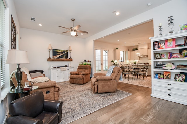 living room with wood-type flooring and ceiling fan