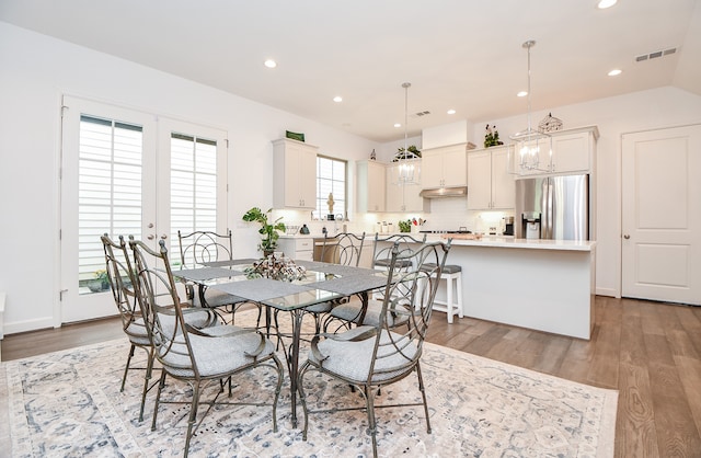 dining area with light wood-type flooring and french doors