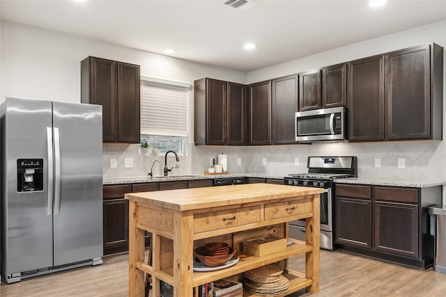 kitchen with dark brown cabinetry, stainless steel appliances, and sink