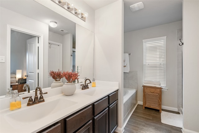 bathroom featuring vanity, hardwood / wood-style floors, and a bathtub