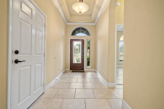 tiled entryway with a tray ceiling