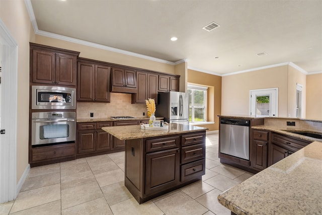 kitchen with dark brown cabinets, stainless steel appliances, a center island, and crown molding