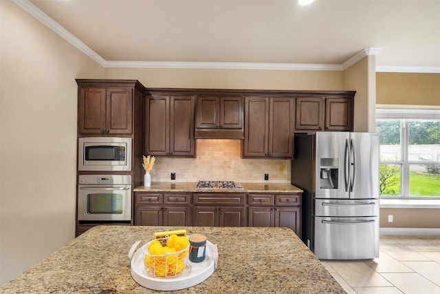 kitchen featuring dark brown cabinets, appliances with stainless steel finishes, and tasteful backsplash