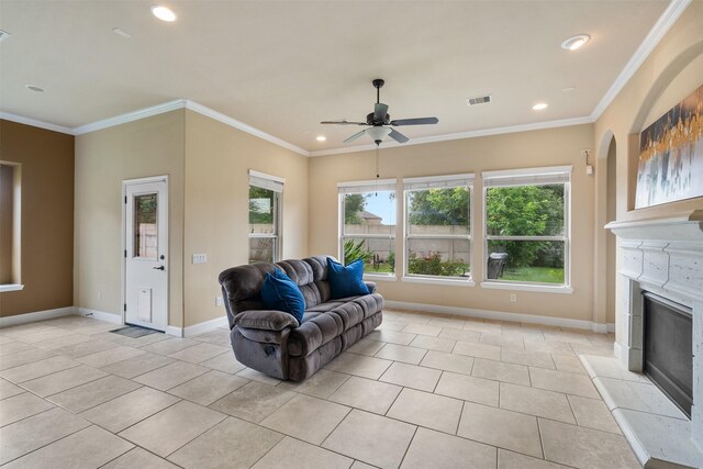 tiled living room with ceiling fan and ornamental molding