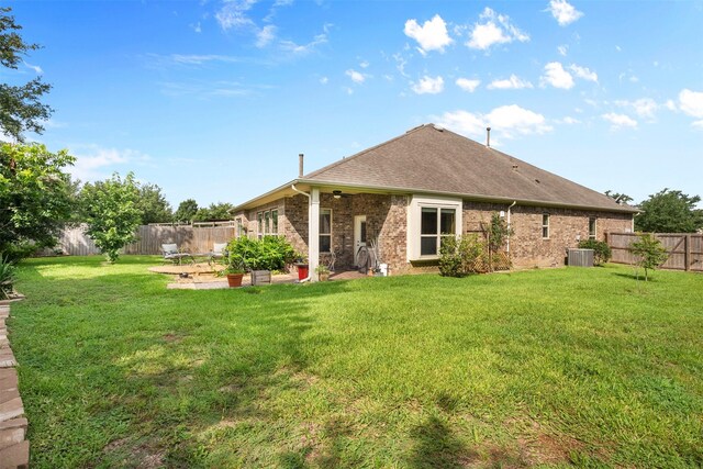 back of house with central air condition unit, a yard, and a patio area