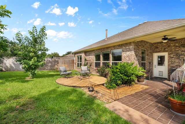 back of house featuring ceiling fan, a lawn, and a patio