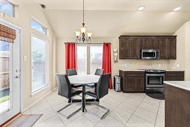 tiled dining area featuring vaulted ceiling and a notable chandelier