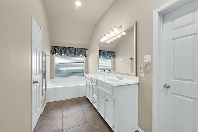 bathroom with tile patterned flooring, a bath, vanity, and vaulted ceiling