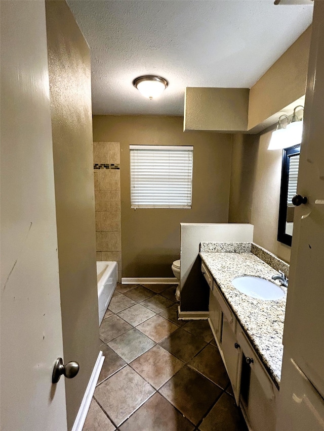 bathroom featuring a wealth of natural light, vanity, a textured ceiling, and toilet