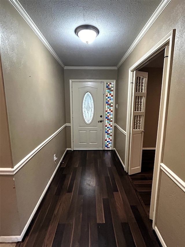 doorway to outside featuring a textured ceiling, dark hardwood / wood-style floors, and crown molding