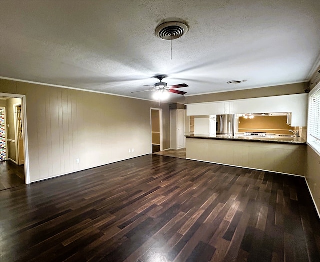 unfurnished living room with a textured ceiling, dark hardwood / wood-style floors, and crown molding