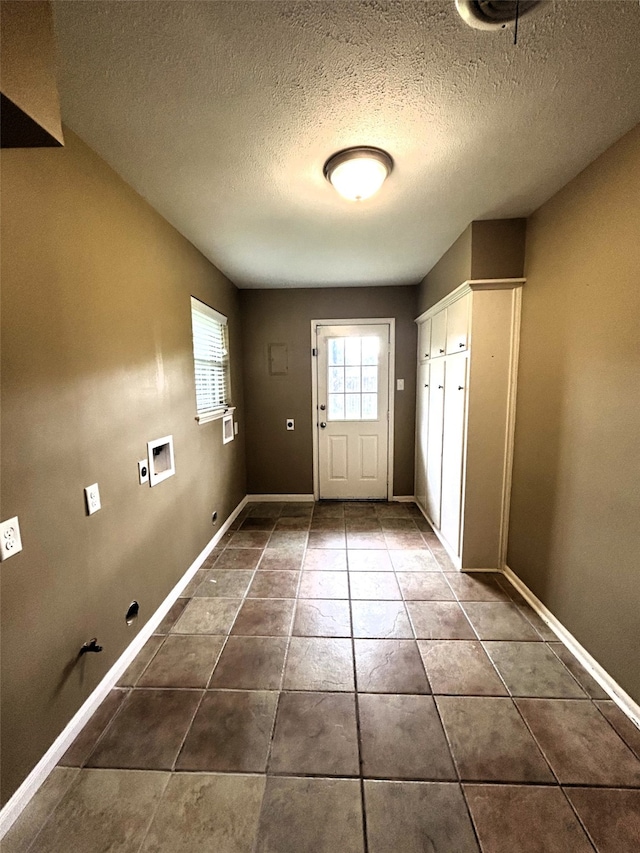 entryway with dark tile patterned floors and a textured ceiling