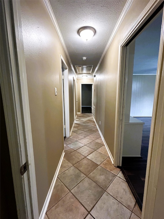 hall featuring tile patterned flooring, a textured ceiling, and crown molding