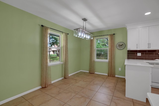 unfurnished dining area featuring a healthy amount of sunlight and light tile patterned floors