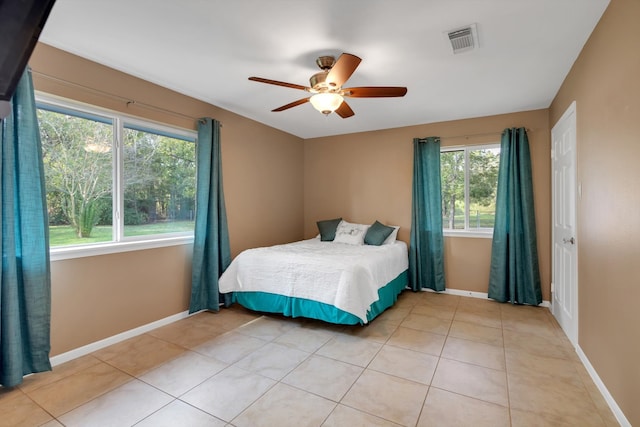 bedroom featuring light tile patterned flooring, multiple windows, and ceiling fan