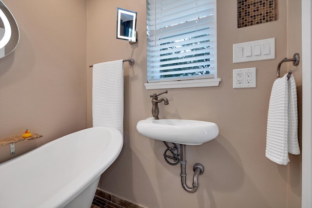 bathroom with a washtub and sink