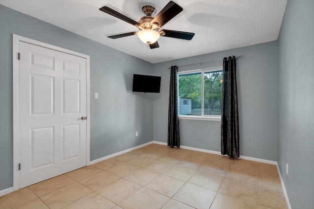 tiled empty room with ceiling fan