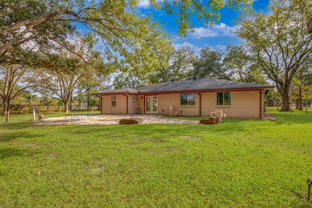 back of property with a yard and a patio