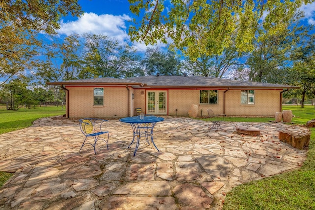 back of house with a lawn, a patio area, french doors, and an outdoor fire pit