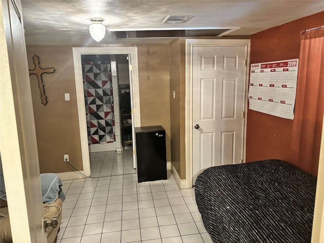 bedroom with light tile patterned flooring and a textured ceiling