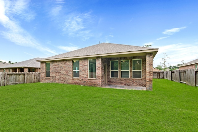 rear view of house featuring a lawn and a patio area