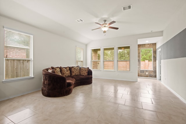 living room with ceiling fan, light tile patterned floors, and lofted ceiling