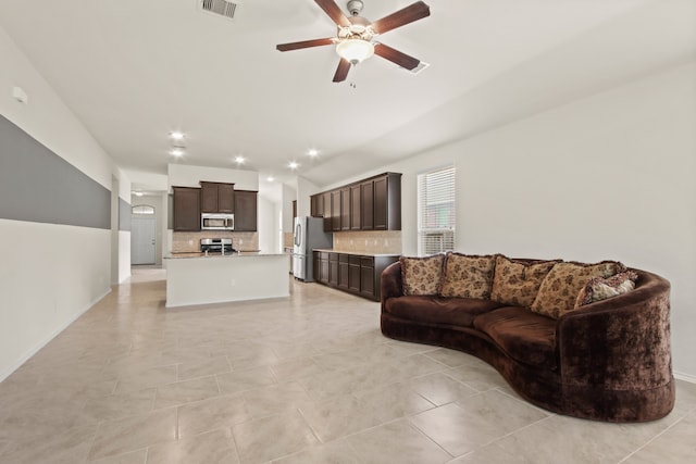 living room with lofted ceiling, ceiling fan, and light tile patterned flooring