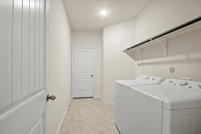 clothes washing area featuring light carpet and independent washer and dryer