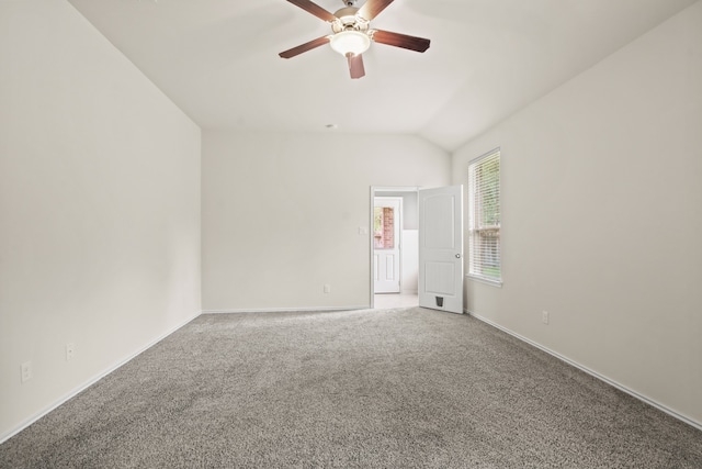 carpeted spare room featuring vaulted ceiling and ceiling fan