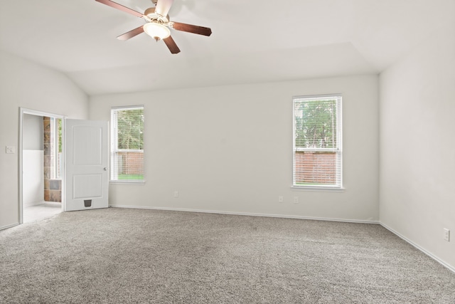 carpeted empty room with a healthy amount of sunlight, ceiling fan, and vaulted ceiling