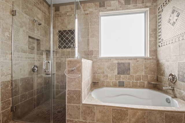 bathroom featuring shower with separate bathtub and tile walls