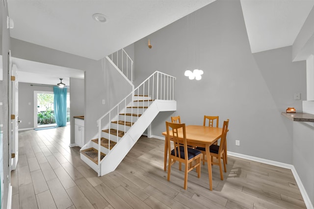 dining space with ceiling fan and light wood-type flooring