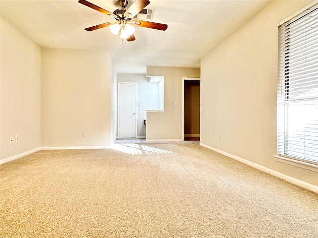 carpeted spare room featuring ceiling fan and a textured ceiling