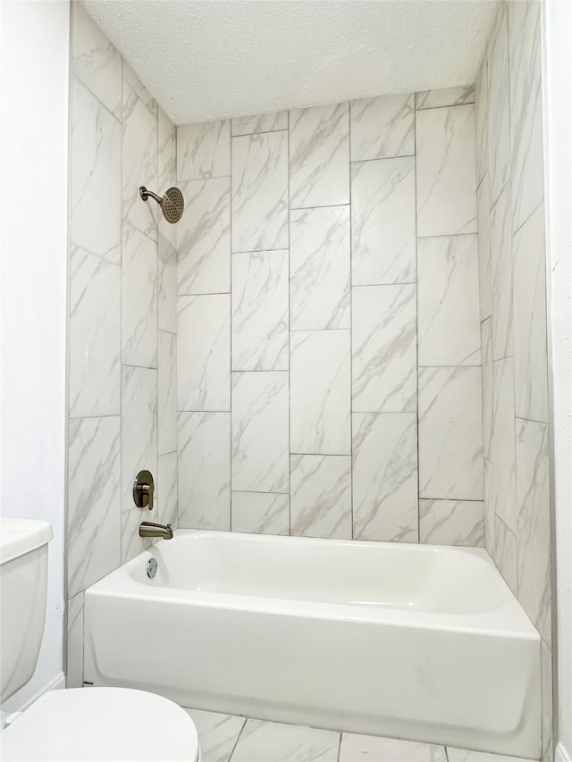 bathroom with tiled shower / bath combo, toilet, and a textured ceiling