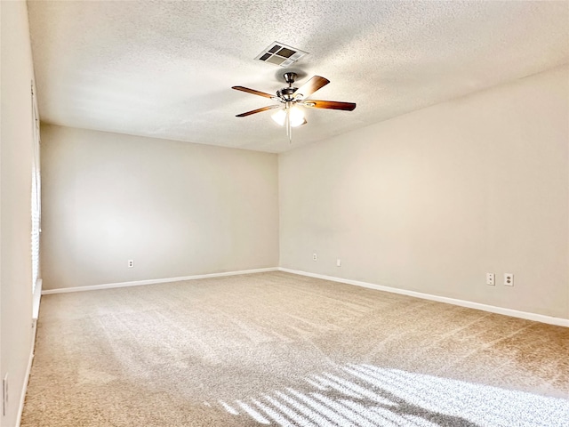 carpeted empty room with ceiling fan and a textured ceiling