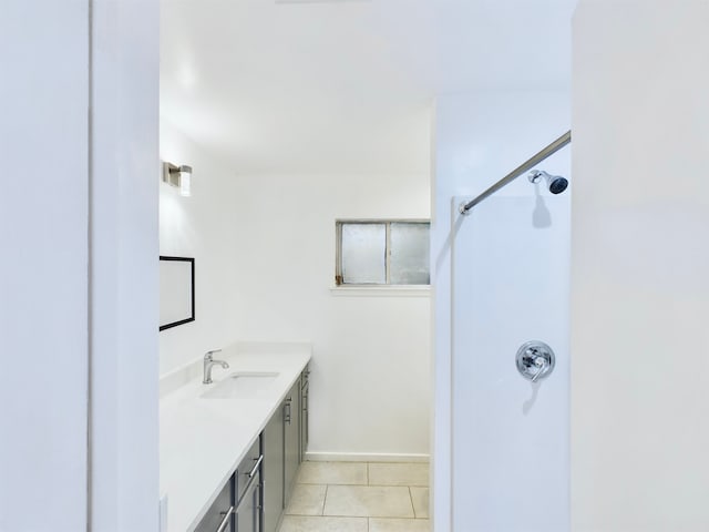 bathroom with walk in shower, vanity, and tile patterned flooring