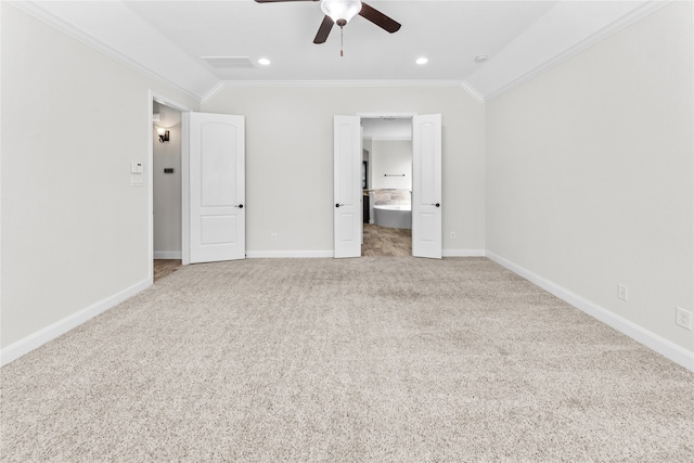 unfurnished bedroom featuring ceiling fan, ensuite bathroom, lofted ceiling, light carpet, and ornamental molding